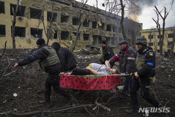 [키이우( 우크라이나)= AP/뉴시스] 마리우폴 폭격의 생존자인 만삭의 산모를 옮기는 구급대원. 이 산모와 아기는 출산 후 모두 사망했다. 