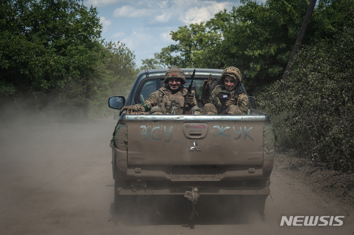 [바흐무트=AP/뉴시스] 우크라이나 군인들이 5일(현지시각) 도네츠크주 바흐무트 인근 최전방에서 '우크라이나군'이라고 쓰인 픽업트럭을 타고 이동하며 웃음 짓고 있다. 2023.06.06.