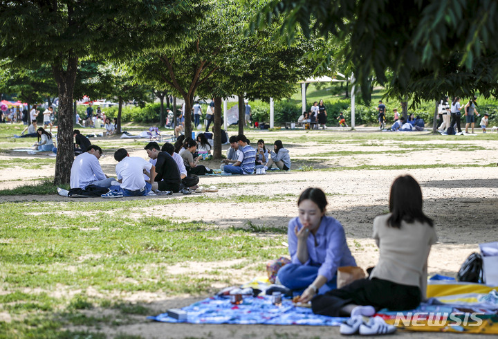 [서울=뉴시스] 정병혁 기자 = 6일 오후 서울 영등포구 여의도한강공원을 찾은 시민들이 그늘에서 즐거운 시간을 보내고 있다. 2023.06.06. jhope@newsis.com