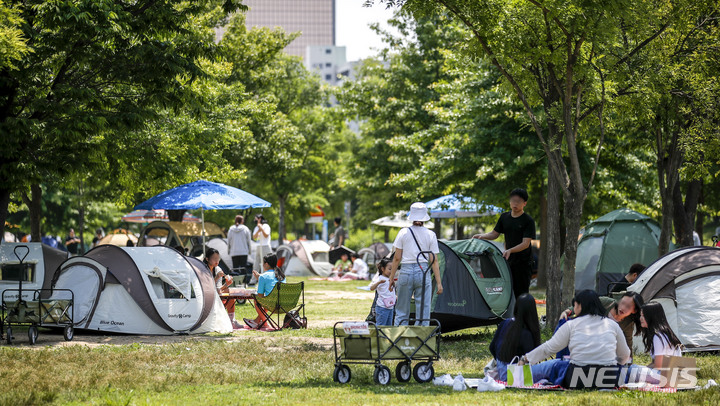[서울=뉴시스] 정병혁 기자 = 지난 6일 오후 서울 영등포구 여의도한강공원을 찾은 시민들이 텐트를 치고 즐거운 시간을 보내고 있다. 2023.06.07. jhope@newsis.com