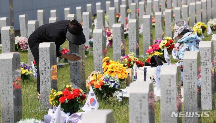 [임실=뉴시스] 현충일인 6일 전북 임실군 임실국립호국원을 찾은 시민들이 묘비를 닦아내고 있다. 2023.06.06. pmkeul@nwsis.com