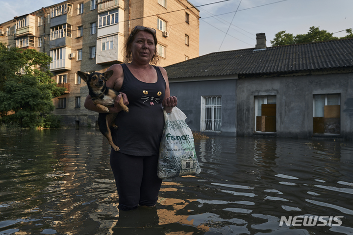 [헤르손=AP/뉴시스] 6일(현지시간) 우크라이나 헤르손 홍수 지역에서 주민이 대피하고 있다. 이날 새벽 러시아군이 점령 중인 우크라이나 노바카호우카 댐 일부가 폭발해 홍수가 발생, 주민들이 대피하고 인근 자포리자 원자력발전소의 냉각수 공급 차질 우려를 빚고 있다. 러시아와 우크라이나 양국은 서로를 배후로 지목했다. 2023.06.07.