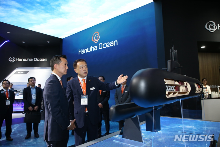 [서울=뉴시스]김동관 부회장이 MADEX(국제해양방위산업전) 한화오션 부스를 방문해 전시된 잠수함을 살펴보며 설명을 듣고 있다.(사진=한화오션 제공)