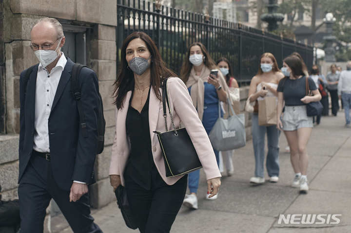 [뉴욕=AP/뉴시스] 7일(현지시간) 미국 뉴욕에서 행인들이 마스크를 낀 채 길거리를 걷고 있다. 뉴욕은 현재 전 세계 최악의 대기질을 기록해 미국 국립기상청은 '야외 활동 자제' 권고를 내렸다. 2023.06.08.
