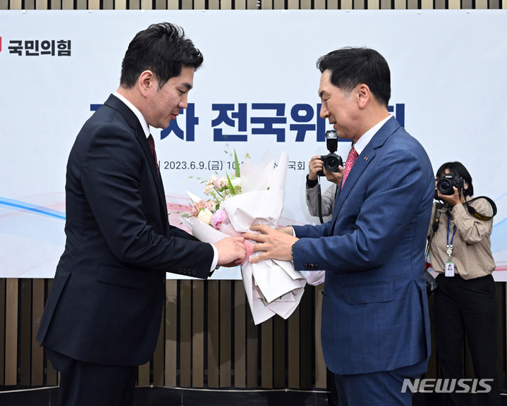 [서울=뉴시스] 추상철 기자 = 김기현 국민의힘 당 대표가 9일 오후 서울 여의도 국회에서 열린 최고위원 당선 결과 발표에서 김가람 신임 최고위원에게 꽃다발을 전달하고 있다. (공동취재사진) 2023.06.09. photo@newsis.com