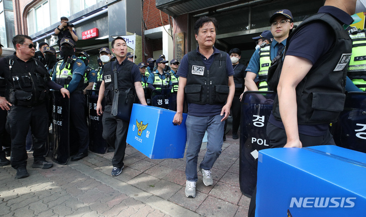 [서울=뉴시스] 최진석 기자 = 경찰 수사관들이 지난 9일 오후 서울 영등포구 대림동 민주노총 건설노조 사무실에서 서울 도심 '1박 2일 집회' 관련 집시법 위반 등 혐의로 압수수색을 마친 후 압수품을 들고 차량으로 이동하고 있다. (공동취재사진) 2023.06.09 photo@newsis.com