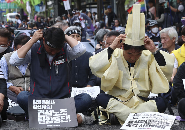 [서울=뉴시스] 김근수 기자 = 건설노조 故 양회동씨의 장례절차가 시작된 17일 서울 중구 세종대로 인근에서 열린 故 양회동 열사 범국민 추모대회에서 양경수 민주노총 위원장과 장옥기 건설노조 위원장이 머리띠를 묶고 있다. 2023.06.17. ks@newsis.com