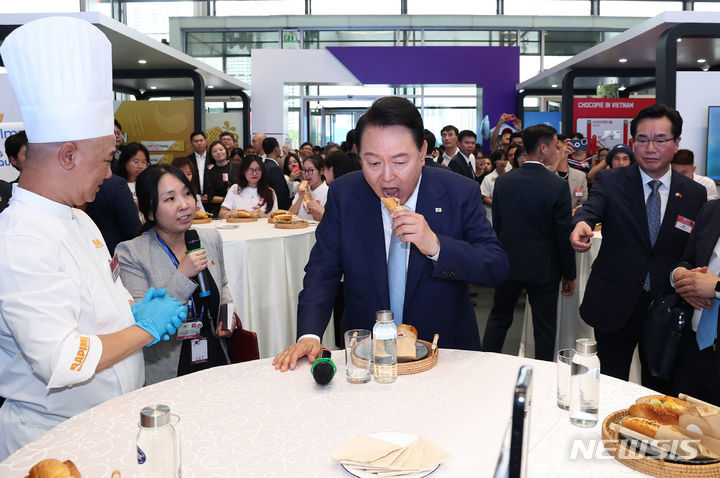 [하노이=뉴시스] 전신 기자 = 베트남을 국빈 방문한 윤석열 대통령이 22일(현지시간) 하노이 국가컨벤션센터에서 열린 한-베트남 파트너십 박람회에서 K-Food 행사장을 찾아 김치로 만든 반미 샌드위치를 시식하고 있다. 2023.06.22. photo1006@newsis.com