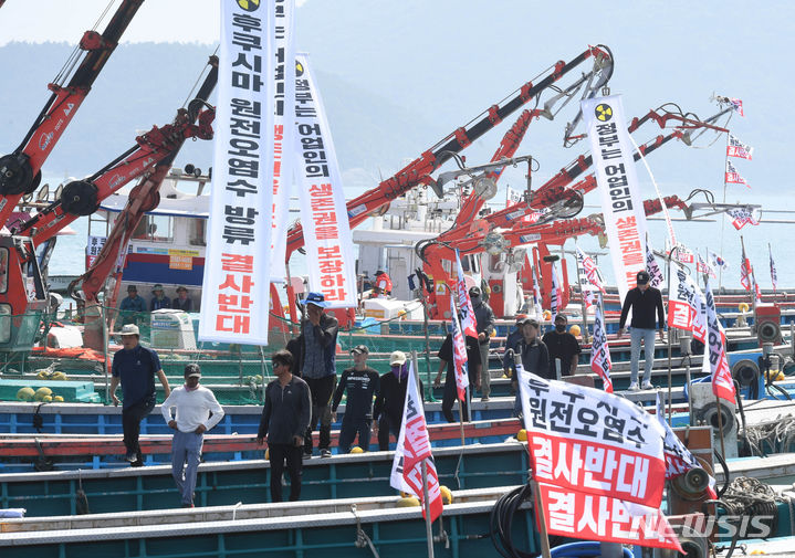 [완도=뉴시스] 변재훈 기자 = 한국수산업경영인연합회 소속 어업인들이 23일 오전 전남 완도군 완도읍 완도항 1부두에 정박한 어선에 '후쿠시마 원전 오염수 방류 결사 반대' 현수막을 내걸고 있다. 2023.06.23. wisdom21@newsis.com