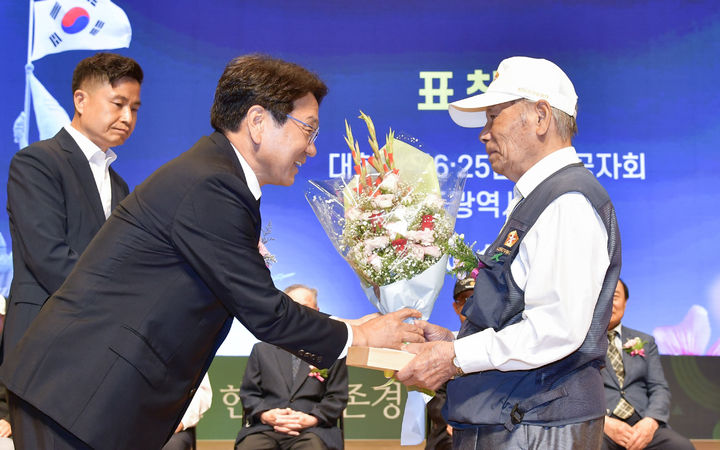 [광주=뉴시스] 강기정 광주시장이 25일 오전 남구 빛고을시민문화관에서 열린 '6·25전쟁 제73주년 기념식'에 참석해 모범유공자에게 표창패를 수여하고 있다. (사진 = 광주시 제공) *재판매 및 DB 금지