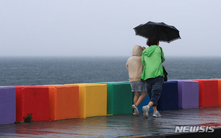 [제주=뉴시스] 우장호 기자 = 지난해 6월25일 오전 제주시 무지개해안도로에서 우산을 쓴 시민이 걸어가고 있다. 기상청에 따르면 제주도는 오는 27일까지 강풍을 동반한 많은 비가 내릴 것으로 전망된다. 2023.06.25. woo1223@newsis.com