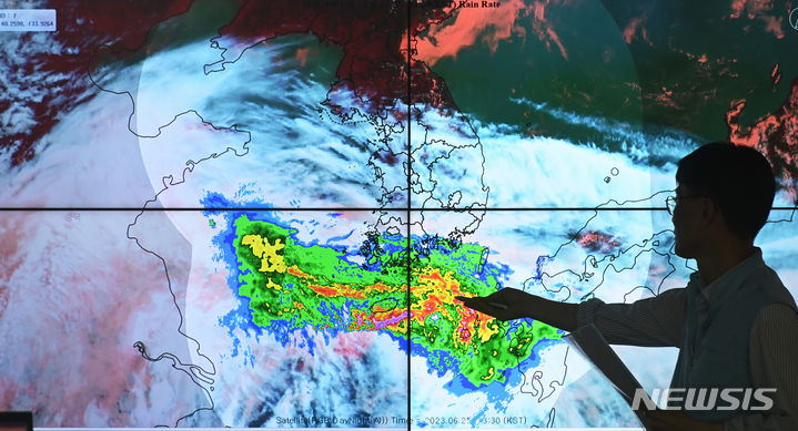 [수원=뉴시스] 김종택 기자 = 장마철에 접어든 지 나흘째인 28일 수요일은 오전까지 남부지방을 중심으로 강하고 많은 비가 내리겠고, 오후에는 곳곳에 소나기가 내리겠다. 특히 전국 대부분 지역이 30도 이상으로 오르겠고, 습도가 높아 체감온도는 더 높을 것으로 전망된다. 사진은 지난 25일 오후 경기도 수원시 권선구 수도권기상청에서 예보관이 많은 양의 수증기를 품고 있는 비구름의 이동 경로를 설명하고 있는 모습. 2023.06.25. jtk@newsis.com