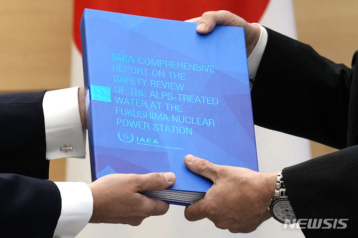 [도쿄=AP/뉴시스] 라파엘 그로시(왼쪽) 국제원자력기구(IAEA) 사무총장이 4일 일본 도쿄의 총리 관저에서 기시다 후미오 일본 총리에게 IAEA의 후쿠시마 오염수 방류 종합보고서를 전달하고 있다. IAEA는 이날 일본 정부의 후쿠시마 제1 원전 내 오염수 방류 계획이 국제 안전기준에 부합한다는 결론을 내린 것으로 알려졌다. 2023.07.05.