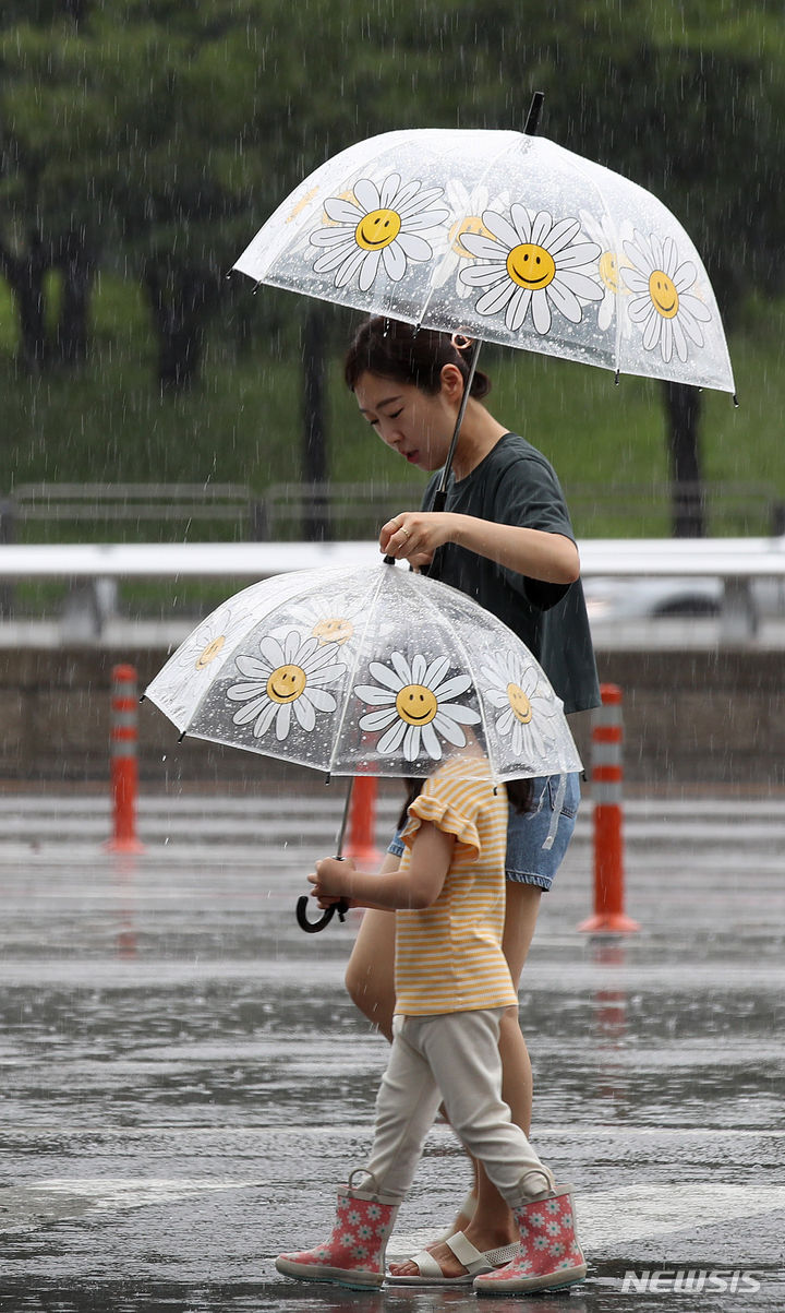 [서울=뉴시스] 조수정 기자 = 전국에 장맛비가 내리고 있는 4일 서울 영등포구 여의도동에서 한 엄마가 아이의 우산이 무거울까 잡아주며 걸어가고 있다. 2023.07.04. chocrystal@newsis.com