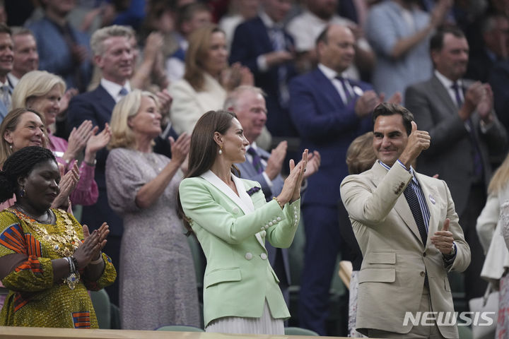[런던=AP/뉴시스] '테니스 황제' 로저 페더러(스위스, 오른쪽)가 4일(현지시각) 영국 런던에서 열리는 2023 윔블던 테니스 대회 여자 단식 이틀째 센터코트 귀빈석에서 관중의 기립박수를 받고 있다. 대회 조직위는 이 대회를 8차례 우승하고 지난해 은퇴한 페더러에 대한 예우로 2분간의 기립박수 이벤트를 마련했다. 왼쪽은 케이트 왕세자빈. 2023.07.05.