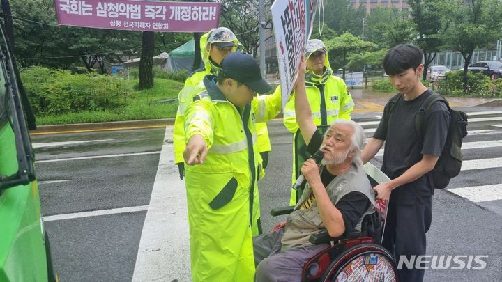 [서울=뉴시스] 서울 시내 버스 운행을 방해한 혐의로 체포된 전국장애인차별철폐연대(전장연) 측이 국가를 상대로 제기한 소송에서 법원이 1000만원의 배상 판결을 내렸다. 사진은 경찰이 지난해 7월14일 박경석 전국장애인차별철폐연대대표를 제지하고 있는 모습.(사진=전국장애인차별철폐연대 제공) 2023.07.14. photo@newsis.com