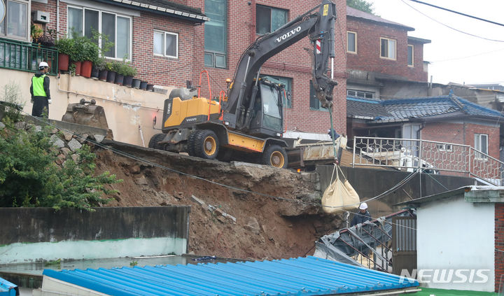 [서울=뉴시스] 황준선 기자 = 14일 오전 폭우로 축대가 무너진 서울 서대문구 홍제천로의 한 도로에서 서대문구 관계자들이 복구작업을 하고 있다. 2023.07.14. hwang@newsis.com