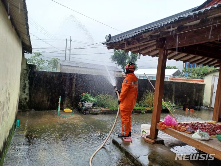 [고성=뉴시스] 홍정명 기자= 집으로 물이 들어온다는 신고를 받고 출동한 경남 고성소방서 대원이 16일 고성군 하이면 봉현리 한 주택에서 배수 작업을 하고 있다.(사진=경남소방 제공) 2023.07.16. photo@newsis.com