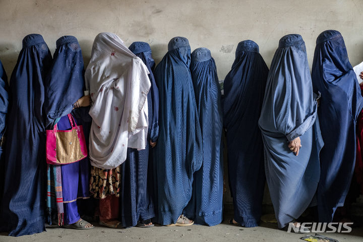 [카불(아프가니스탄)=AP/뉴시스] 유엔아프간지원단(UNAMA)이 최근 발표한 보고서에서 탈레반이 아프간 여성과 소녀들에 대한 제한을 더욱 강화했다고 AP통신은 17일(현지 시간) 보도했다. 사진은 구호 단체에서 나누어주는 식량을 배급받기 위해 줄을 기다리는 아프간 여성들의 모습. 2023.07.19. 