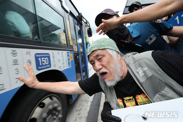 [서울=뉴시스] 김명년 기자 = 20일 전장연에 따르면 내년도 예산안이 나오는 오는 9월까지는 지하철 탑승 시위를 하지 않는다. 예산안에 장애인 이동권 관련 예산이 포함되는지를 보고 향후 지하철 지연 시위 진행 여부를 결정한다는 입장이다. 사진은 박경석 전국장애인차별철폐연대 대표와 회원들이 지난 18일 오후 혜화동로터리에서 '서울시의 전장연 탄압 중단'을 촉구하며 버스 탑승 시위를 벌이는 모습 2023.07.18. kmn@newsis.com