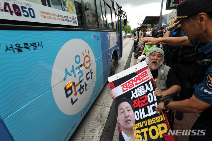 [서울=뉴시스] 김명년 기자 = 박경석 전국장애인차별철폐연대 대표와 회원들이 18일 오후 혜화동로터리에서 '서울시의 전장연 탄압 중단'을 촉구하며 버스 탑승 시위를 벌이고 있다. 2023.07.18. kmn@newsis.com