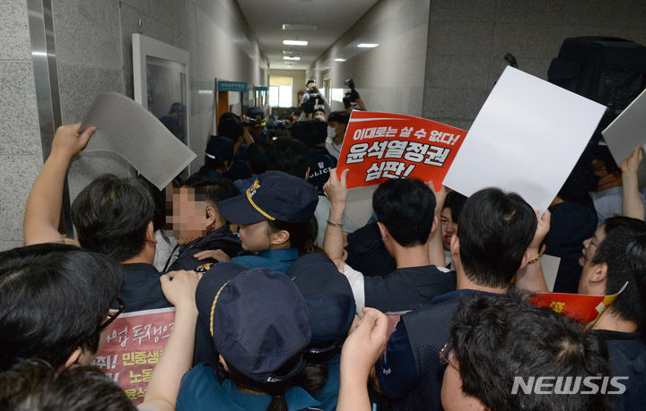 [울산=뉴시스] 배병수 기자 = 울산시민연대 회원들이 19일 오전 울산시의회 3층 대회의실앞에서 학교민주시민교육조례 폐지 반대를 촉구하며 회의장 진입을 시도, 시의회, 경찰 관계자들과 몸싸움을 하고 있다. 2023.07.19. bbs@newsis.com