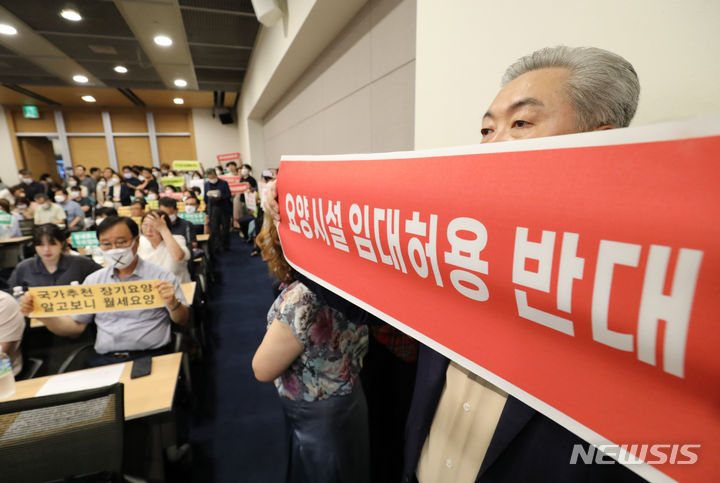 [서울=뉴시스] 황준선 기자 =지난해 7월19일 오전 서울 중구 대한상공회의소에서 열린 신노년층을 위한 요양시설 서비스 활성화 방안마련 정책연구 공청회에서 한국노인장기요양기관협회, 한국사회복지사협회 등 단체원들이 보건복지부의 요양시설 임대 허용 정책 추진에 반대하는 피켓을 들고 있는 모습. 2023.07.19. hwang@newsis.com