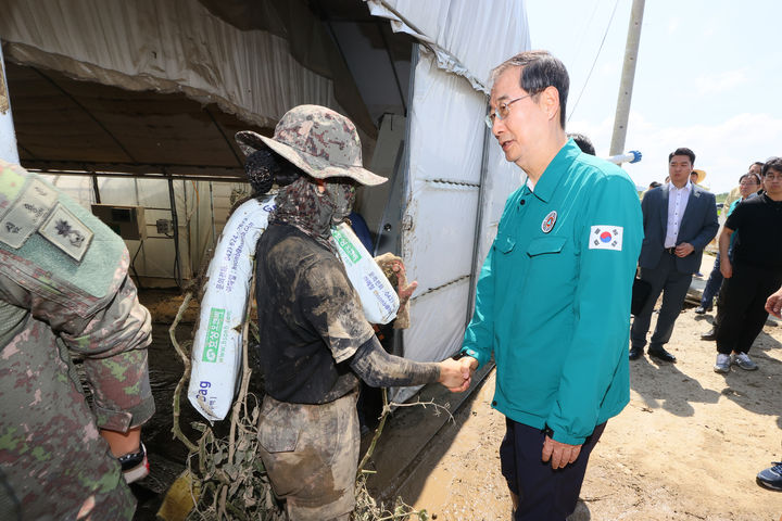 [세종=뉴시스] 강종민 기자 = 한덕수 국무총리는 20일 "복구현장에 가보니 군과 경찰의 고생이 큰 상황"이라며 "안전관리, 충분한 휴식 등에 신경써달라"고 강조했다. 사진은 지난 19일 집중호우 피해를 입어 특별재난지역으로 지정된 충남 청양군 청남면 인양리를 방문, 복구작업을 벌이던 장병을 격려하는 한 총리. (사진=총리실 제공) 2023.07.19. photo@newsis.com *재판매 및 DB 금지