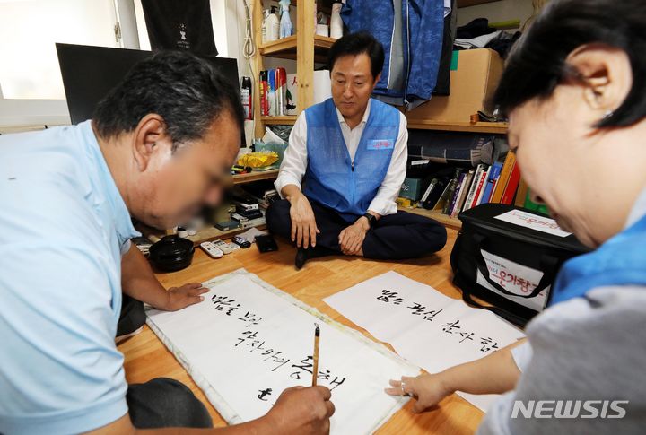 [서울=뉴시스] 고승민 기자 = 20일 오후 서울 용산구 동자동에서 쪽방촌 주민이 오세훈 시장에게 전달할 '마음을 모아 약자와의 동행'이라는 글을 적고 있다. 이날 오 시장은 동자동 쪽방촌을 찾아 몸이 불편한 쪽방촌 주민들을 위해 여름나기 물품을 직접 전달했다. 서울시는 이날 오후 쪽방주민을 위한 수요맞춤형 물품배분 시스템인 동행스토어 '온기창고'가 개소식을 열고 다음달 1일부터 운영에 들어간다고 밝혔다. (공동취재사진) 2023.07.20. photo@newsis.com