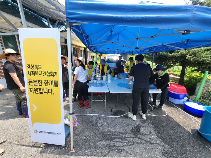 [안동=뉴시스] 경북도 종합사회복지관 긴급봉사단이 지난 21일 호우피해가 심한 문경지역을 찾아 복구인력과 주민들을 위한 식사를 제공하고 있다. (사진=경북도 제공) 2023.07.23 *재판매 및 DB 금지