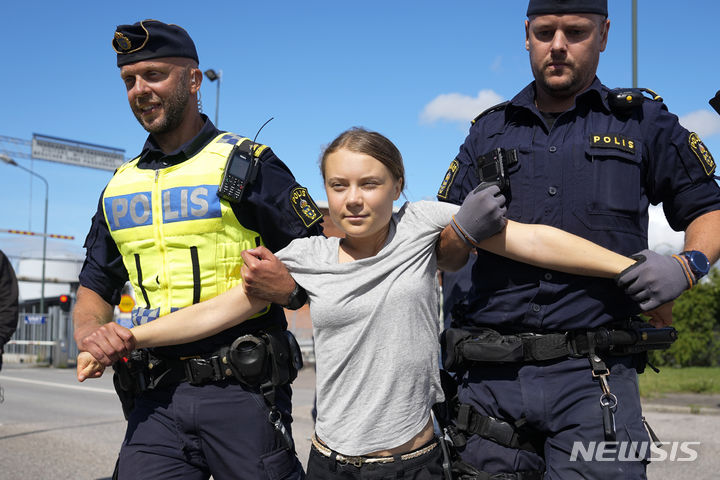 [말뫼=AP/뉴시스] 스웨덴 기후 운동가 그레타 툰베리가 24일(현지시각) 스웨덴 말뫼의 석유 시설 입구를 봉쇄한 혐의로 경찰에 연행되고 있다. 툰베리는 지난달 같은 곳에서 시위를 벌이던 중 교통에 방해가 된다는 이유로 장소를 옮기라는 경찰의 지시를 따르지 않은 '경찰 불복종' 혐의로 벌금형(약 30만 원)을 선고받은 지 불과 몇 시간 만에 다시 시위를 벌였다. 2023.07.25.