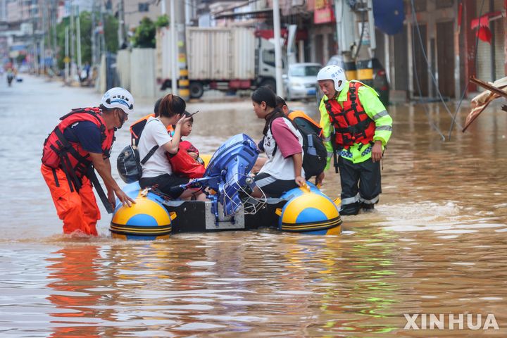 (230729) -- QUANZHOU, July 29, 2023 (Xinhua) -- Members from a civilian rescue team transfer flood-stranded people with a rubber boat in Quanzhou, southeast China's Fujian Province, July 29, 2023. Typhoon Doksuri, the fifth typhoon of this year, made landfall in east China's Fujian Province on Friday morning, bringing with it powerful winds and heavy rain. (Xinhua)