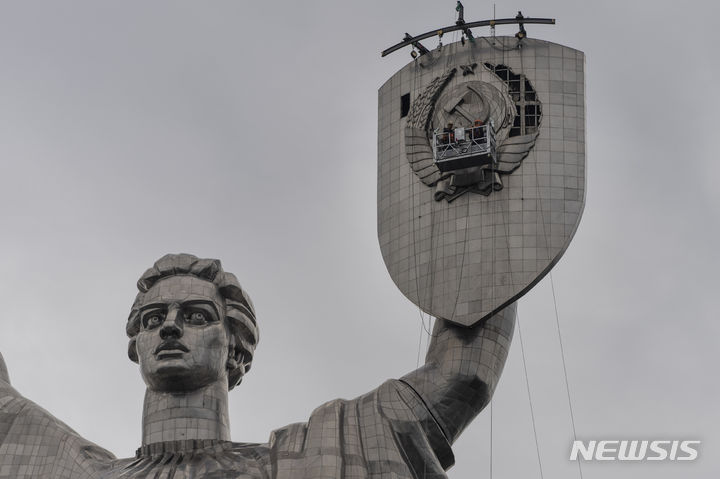 [키이우=AP/뉴시스] 지난달 31일(현지시각) 우크라이나 키이우에서 근로자들이 우크라이나 조국 기념비인 '바티키우시나 마티'의 방패에 있는 구소련의 표상을 제거하고 있다. 2023.08.01.