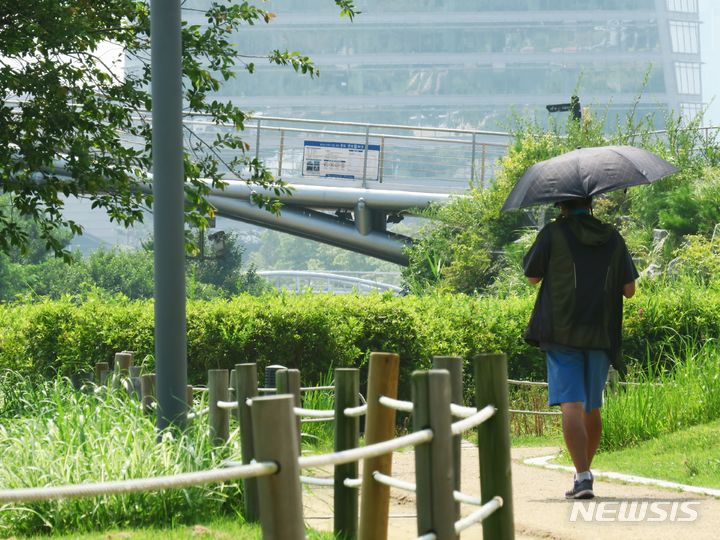 [인천=뉴시스] 김동영 기자 = 인천 연수구 송도 센트럴파크에서 시민이 양산으로 햇빛을 피하며 발걸음을 옮기고 있다. 사진과 기사는 관련 없음. 2023.8.1. dy0121@newsis.com