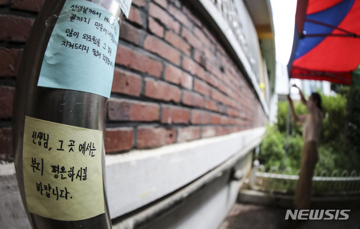 [서울=뉴시스] 김근수 기자 = 지난 7일 오전 서울 서초구 서이초등학교 1학년 6반 교실 외벽 앞에서 한 선생님이 추모를 하고 있다. 서울시교육청에 따르면 고인이 마지막으로 담임을 맡았던 서이초등학교 1학년 6반 교실을 당분간 보존하고 외벽을 추모공간으로 조성한다다. 2023.08.18. ks@newsis.com