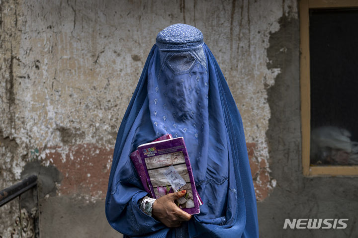 [카불=AP/뉴시스] 아프가니스탄 탈레반 정권이 여성의 대학 진학을 금지하면서 해외 유학에 눈 돌리는 아프가니스탄 여성들이 늘고 있는 가운데 탈레반 정권이 여성의 유학을 위한 출국 또한 막고 있다고 28일(현지시간) 영국 BBC는 보도했다. 사진은 아프리카에서 운영되고 있는 비정규 과정인 지하 학교에서 공부를 마친 후 귀가하는 40대 여성. 2023.08.29. 