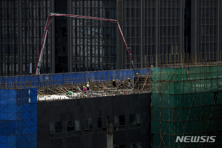 [베이징=AP/뉴시스]사진은 지난 6일 중국 베이징의 한 재건축 빌딩 건설현장에서 작업자들이 기계를 사용해 시멘트를 붓고 있는 모습. 2023.08.17.