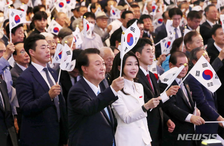 [서울=뉴시스] 홍효식 기자 = 윤석열 대통령과 부인 김건희 여사가 15일 오전 서울 서대문구 이화여대 대강당에서 열린 제78주년 광복절 경축식에서 만세삼창을 한 뒤 태극기를 흔들고 있다. 2023.08.15. yesphoto@newsis.com