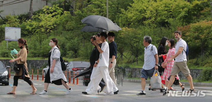 [서울=뉴시스] 김금보 기자 = 소나기가 내렸다 그치기를 반복한 22일 오후 명동역 인근에서 사람들이 우산을 쓰거나 접은 채 이동하고 있다. 2023.08.22. kgb@newsis.com