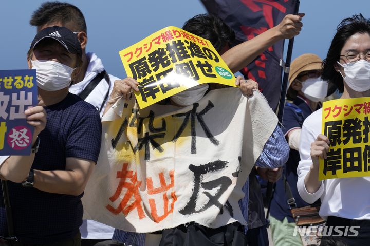 [나미에=AP/뉴시스] 24일 일본 후쿠시마현 나미에 해변에서 시위대가 후쿠시마 다이이치 원자력발전소를 향해 오염수 방류 반대 시위를 하고 있다. 후쿠시마 원전 운영회사인 도쿄전력은 이날 오후 1시부터 오염수 방류를 시작했다고 밝혔다. 이들이 들고 있는 현수막 등에는 '오염수 해양 방류 반대'라고 쓰여 있다. 2023.08.24.