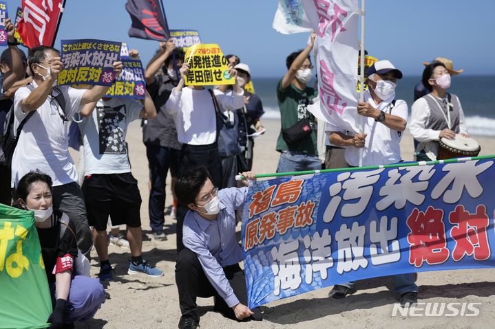 [나미에=AP/뉴시스] 24일 일본 후쿠시마현 나미에 해변에서 시위대가 후쿠시마 다이이치 원자력발전소를 향해 오염수 방류 반대 시위를 하고 있다. 후쿠시마 원전 운영회사인 도쿄전력은 이날 오후 1시부터 오염수 방류를 시작했다고 밝혔다. 이들이 들고 있는 현수막 등에는 '오염수 해양 방류 반대'라고 쓰여 있다. 2023.08.24.