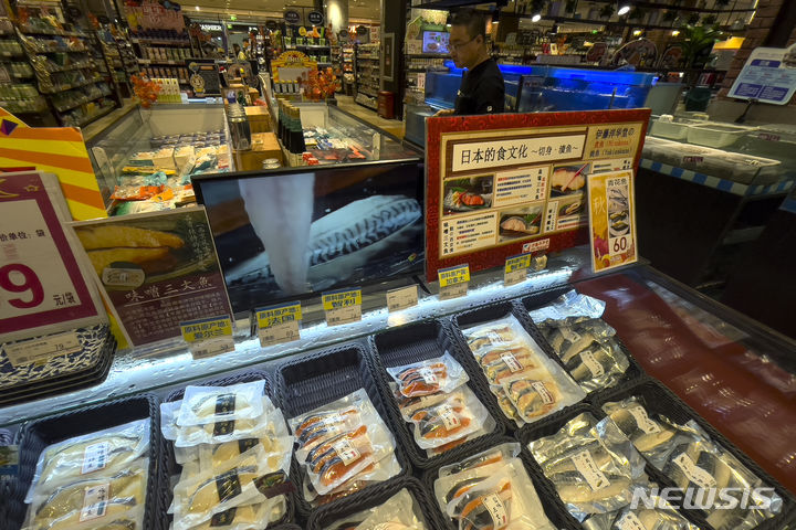 [베이징=AP/뉴시스]사진은 지난 24일 중국 베이징의 한 일본계 슈퍼마켓에서 한 남성이 일본식 요리법을 보여주는 안내문과 모니터 부근에서 칠레, 프랑스, 캐나다에서 수입된 해산물을 살펴보는 모습. 2023.08.31.