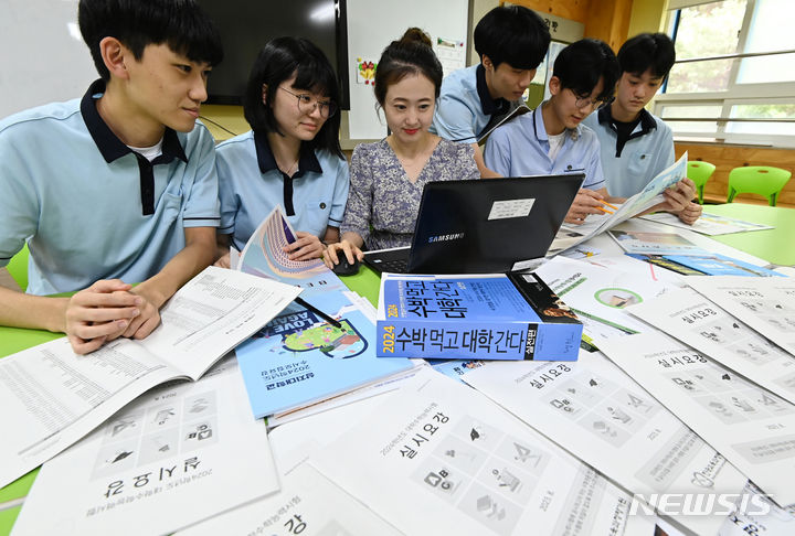 [수원=뉴시스] 김종택 기자 = 2024학년도 대학수학능력시험 원서접수가 시작된 24일 경기도 수원시 조원고등학교에서 고3 학생들이 선생님과 수능실시요강 등을 살펴보고 있다. 2023.08.24. jtk@newsis.com