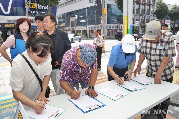 [제천=뉴시스] 이도근 기자= 25일 충북 제천시 중앙동 시민회관 앞에서 열린 '후쿠시마 방사능 오염수 해양방류 중단 촉구대회'에서 시민들이 반대 서명을 하고 있다. 2023.8.25. nulha@newsis.com