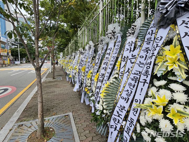 [용인=뉴시스] 양효원 기자 = 4일 오후 경기 용인시 기흥구 한 고등학교 앞에 전날 사망한 교사를 추모하는 조화가 놓여있다. 지난 3일 오전 10시 35분께 이 학교 체육교사 A(61)씨가 성남시 청계산 등산로에서 숨진 채 발견됐다. 2023.7.18. hyo@newsis.com