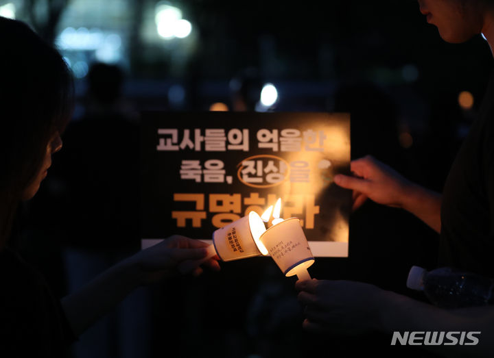 [서울=뉴시스] 김명년 기자 = 공교육 멈춤의 날인 4일 오후 서울 서초구 서울교육대학교 운동장에서 열린 '서이초 사망교사 49재 추모 촛불집회'에서 참석자들이 촛불을 이어 붙이고 있다. 서울교대는 고인의 모교다. 2023.09.04. kmn@newsis.com