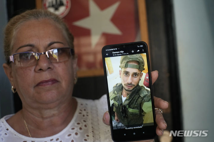 [아바나=AP/뉴시스]우크라이나 전쟁에 참전중인 아들을 둔 한 쿠바 여성이 지난 8일(현지시간) 아바나에 있는 자신의 집에서 인터뷰를 하던 중 8월22일 스페인어로 "나는 이미 얽혔다"라고 적힌 아들의 군복 입은 사진을 보여주고 있다. 이 여성은 아들과 다른 쿠바인들이 건설 일을 약속받고 7월 말 러시아로 갔지만, 자신의 아들은 우크라이나에서 러시아를 위해 싸우도록 모집된 쿠바인들 중 한 명이라고 말했다. 2023.09.28.