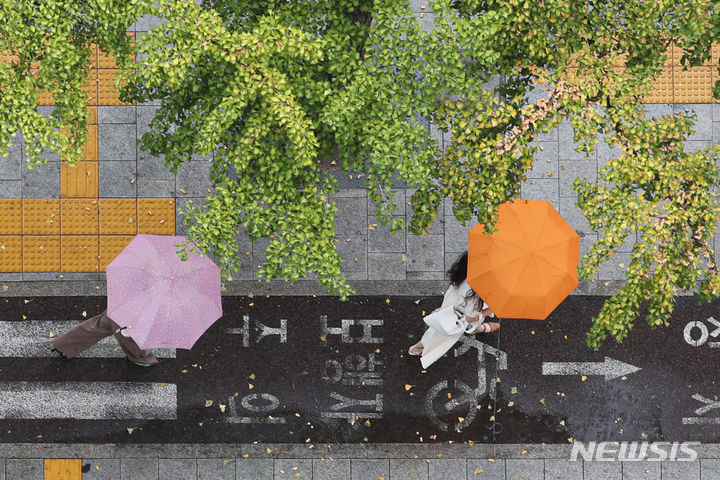 [서울=뉴시스] 권창회 기자 = 비가 내리고 있는 13일 오후 서울 종로구 광화문역 인근에서 시민들이 우산을 쓰고 이동하고 있다. 2023.09.13. kch0523@newsis.com