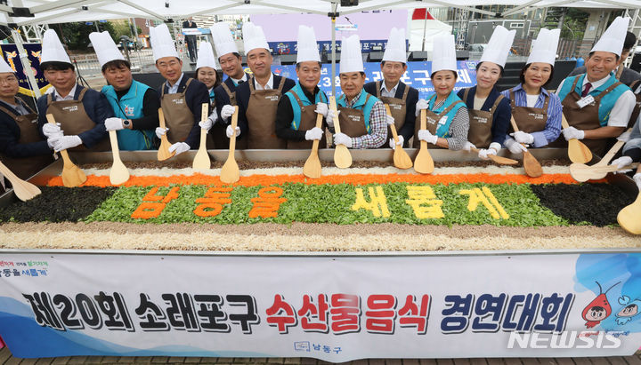 [인천=뉴시스] 전진환 기자 = 제23회 소래포구축제가 열린 15일 오전 인천 남동구 소래포구 해오름광장에서 맹성규 더불어민주당 의원, 박종효 남동구청장, 오용환 남동구의회의장 등 참석자들이 대형 비빔밥을 비비는 퍼포먼스를 하고 있다. 2023.09.15. amin2@newsis.com