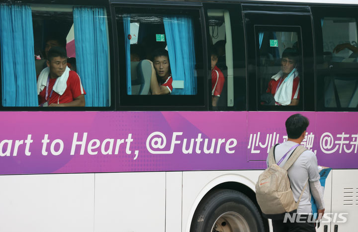 [진화(중국)=뉴시스] 고승민 기자 = 2022 항저우 아시안게임에 출전하는 북한 축구대표팀이 18일(현지시간) 숙소가 마련된 중국 진화시의 한 호텔로 들어서고 있다. 버스 밖에 대한민국 대표팀 관계자가 서 있다. 2023.09.18. kkssmm99@newsis.com
